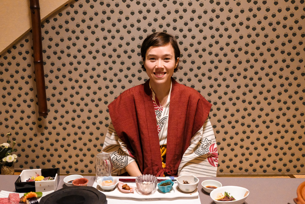 woman in traditional yukata in front of Japanese dinner set